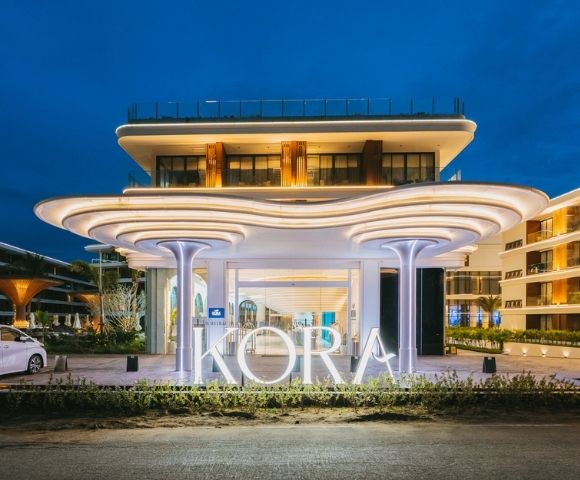Modern resort entrance at dusk with illuminated 