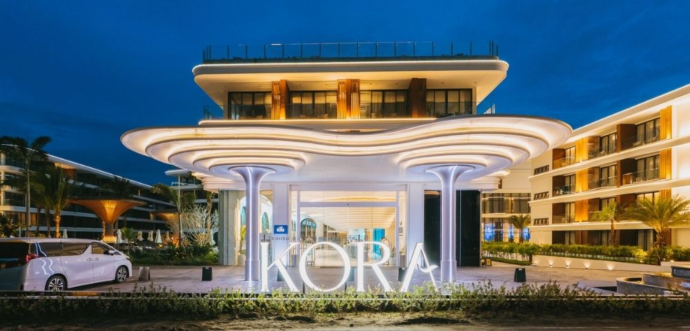 Modern resort entrance at dusk with illuminated 