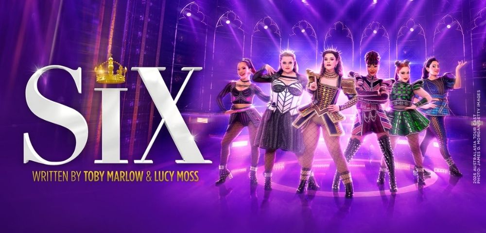 Promotional image for SIX: six women in glittering Tudor-inspired costumes perform on a purple-lit stage, with bold title text and a crown.