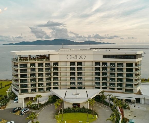 Aerial view of a modern, multi-story hotel building with balconies, labeled 