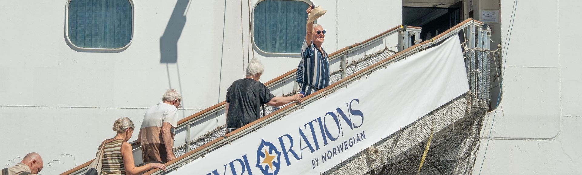 People boarding a cruise ship via a gangway with 