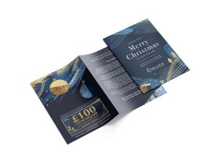 Holiday-themed greeting card with navy and gold accents, reading "Merry Christmas" and containing a £100 cruise voucher, conveying festive elegance.